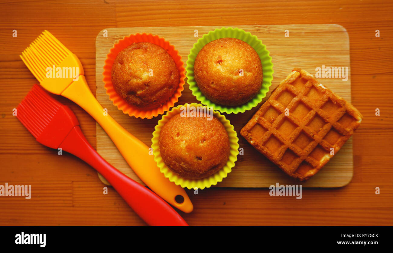 Einfachen mini Muffins in bunten Silikon Backformen. Silikon cup baking  Cupcakes und Silikon Pinsel. Küche und kochen Konzept auf hölzernen  Hintergrund Stockfotografie - Alamy