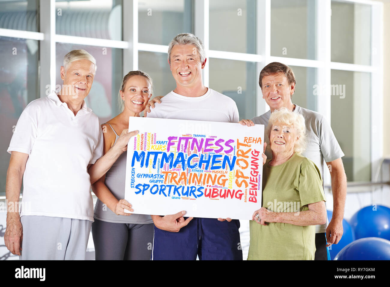 Senioren halten Poster im Fitnesscenter mit Keyword Cloud über Fitness Stockfoto