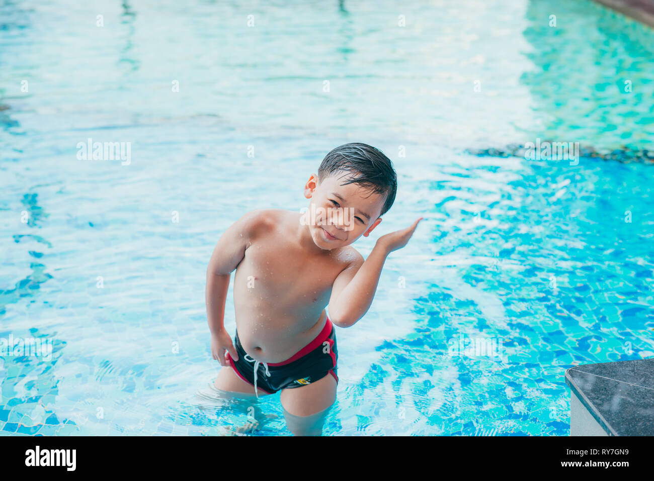 Cute asian kid Reinigung Ohren nach dem Schwimmen in einem Pool Stockfoto