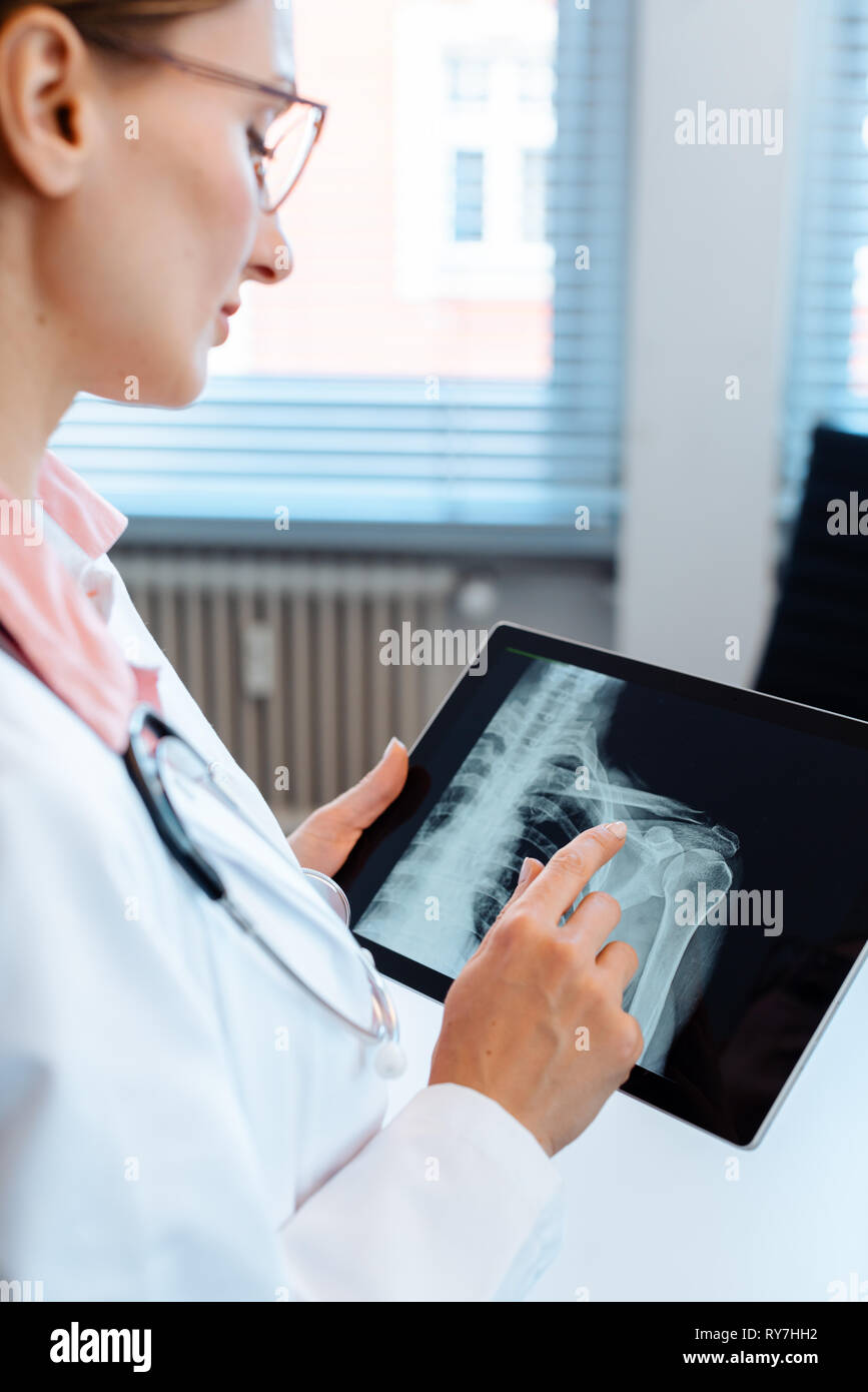 Arzt suchen an x-ray Bild einer Schulter auf Ihrem Tablet-PC Stockfoto