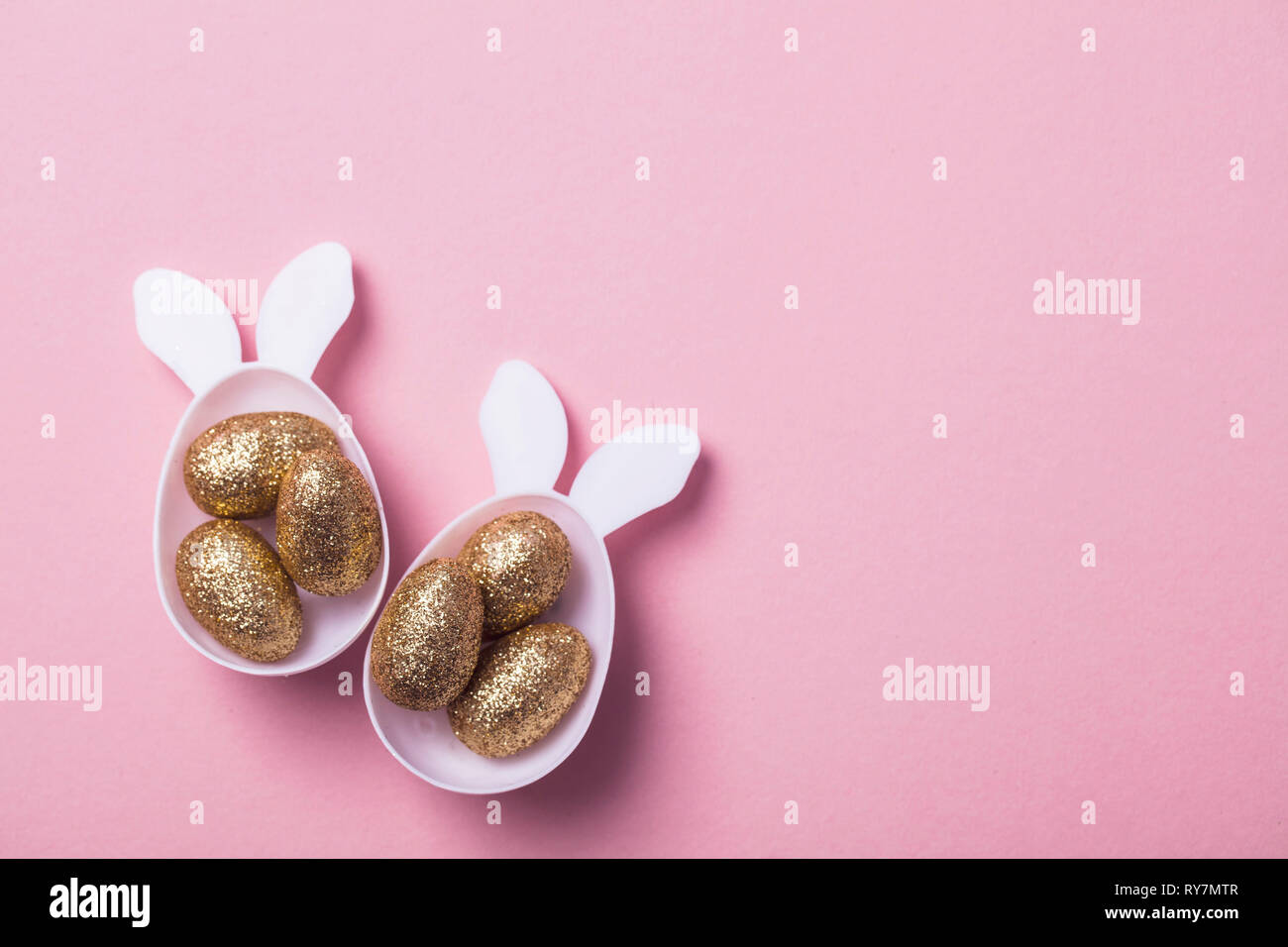 Gold Glitzer Eier in einem weißen Osterhase ei Form mit Ohren Stockfoto