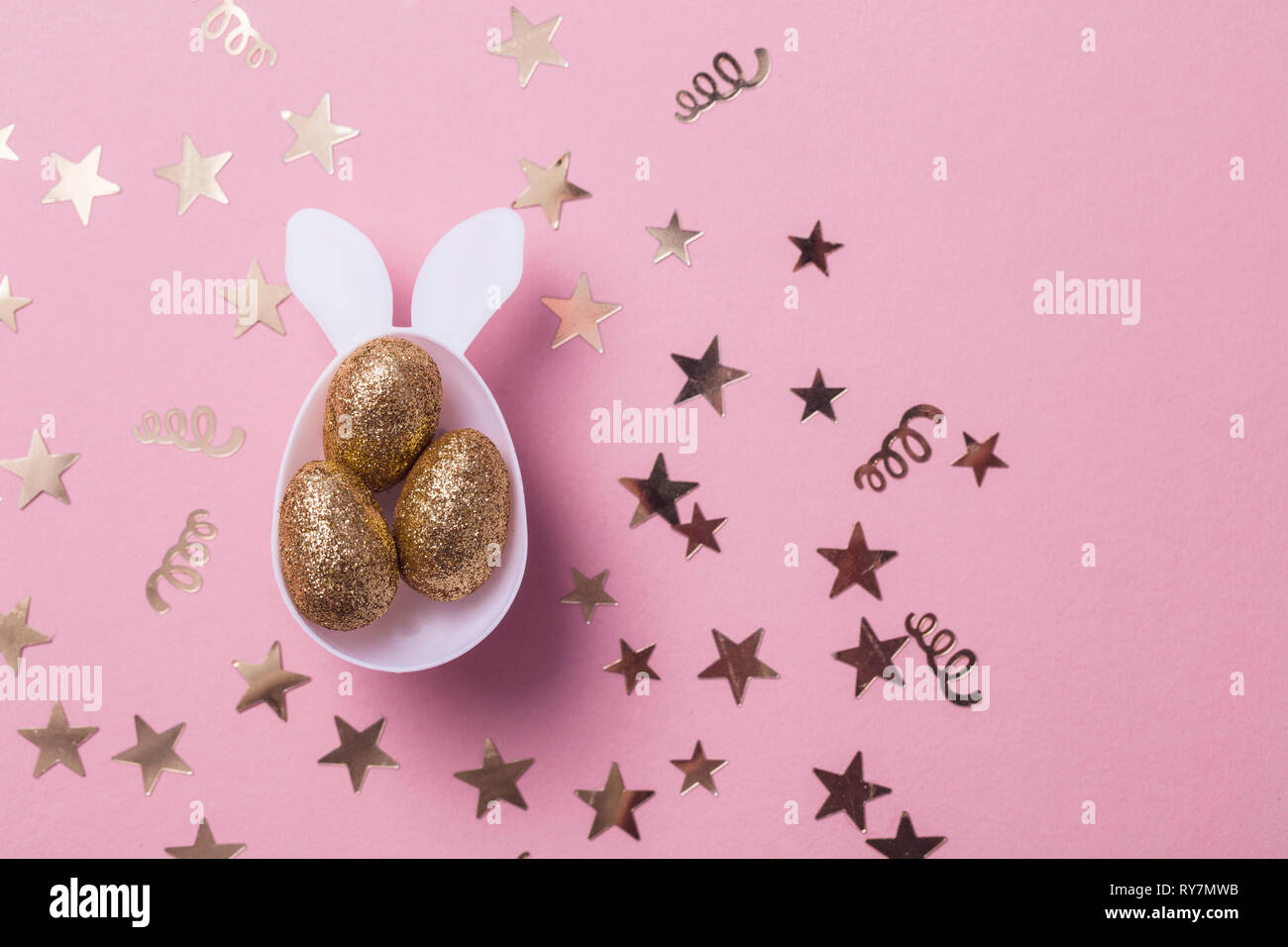 Gold Glitzer Eier in einem weißen Osterhase ei Form mit Ohren Stockfoto