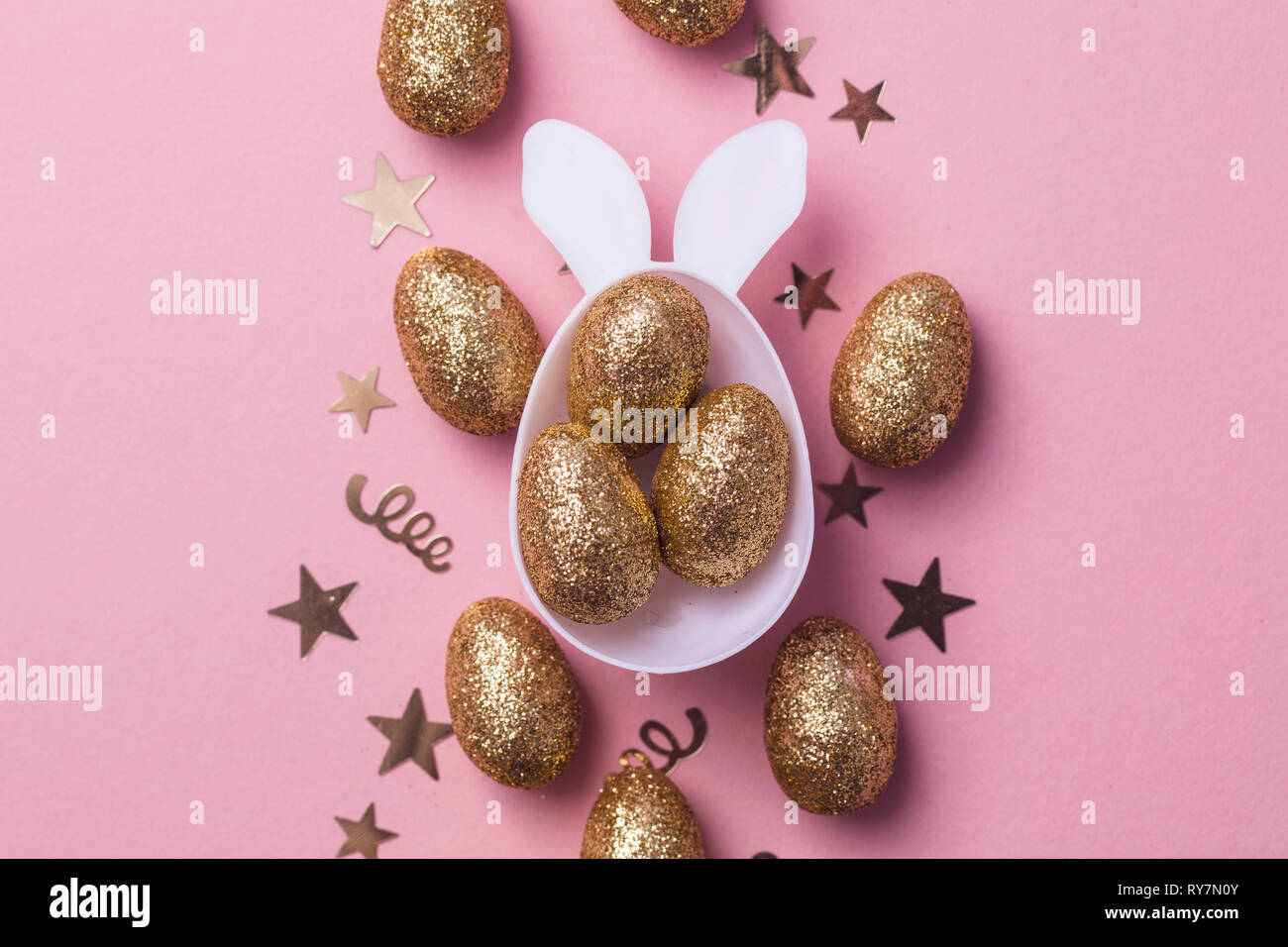 Gold Glitzer Eier in einem weißen Osterhase ei Form mit Ohren Stockfoto