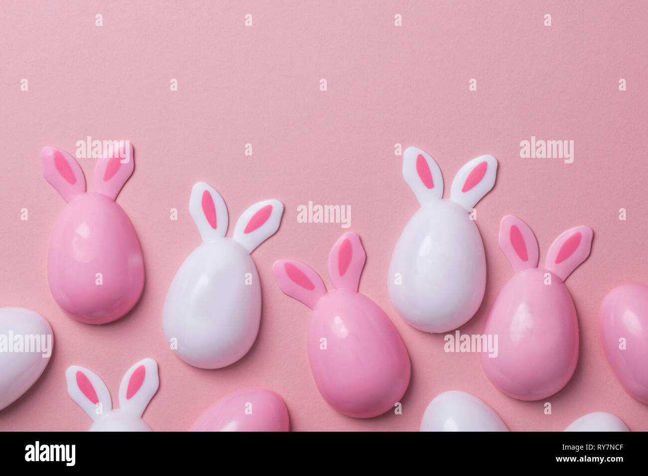 Ostereier mit Hasenohren auf einem Pastell rosa Hintergrund Stockfoto