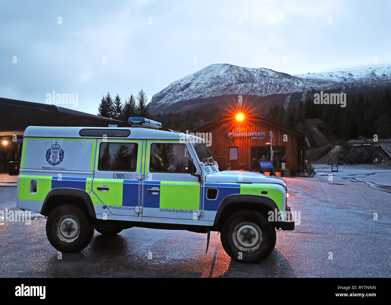 Ein polizeifahrzeug an der Nevis Range Mountain Resort mit Ben Nevis, wo zwei Kletterer gestorben sind und zwei weitere haben nach einem Lawinenabgang auf dem Berg verletzt worden. Stockfoto