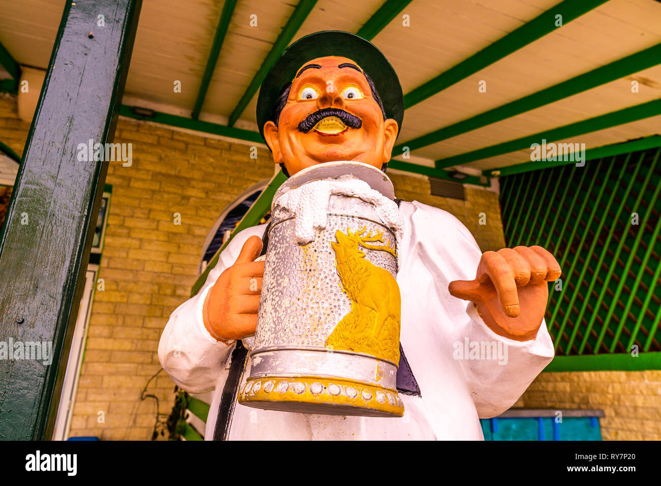 Pefkochori Promenadenstraße lustige Skulptur eines deutschen Mann mit Schnurrbart Holding ein Bier Glas und zeigt mit dem Finger Stockfoto