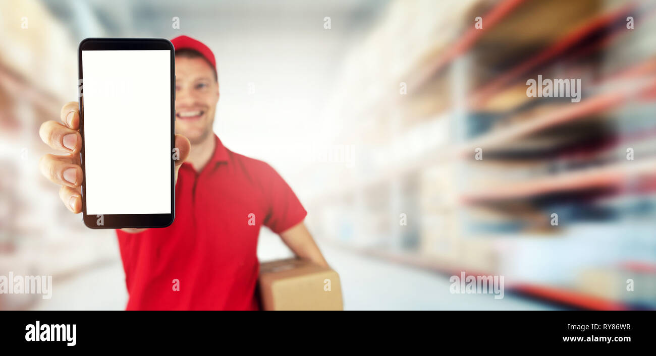 Junge lächelnde Lieferservice Kurier zeigt leere Smart Phone ab Lager Platz kopieren Stockfoto