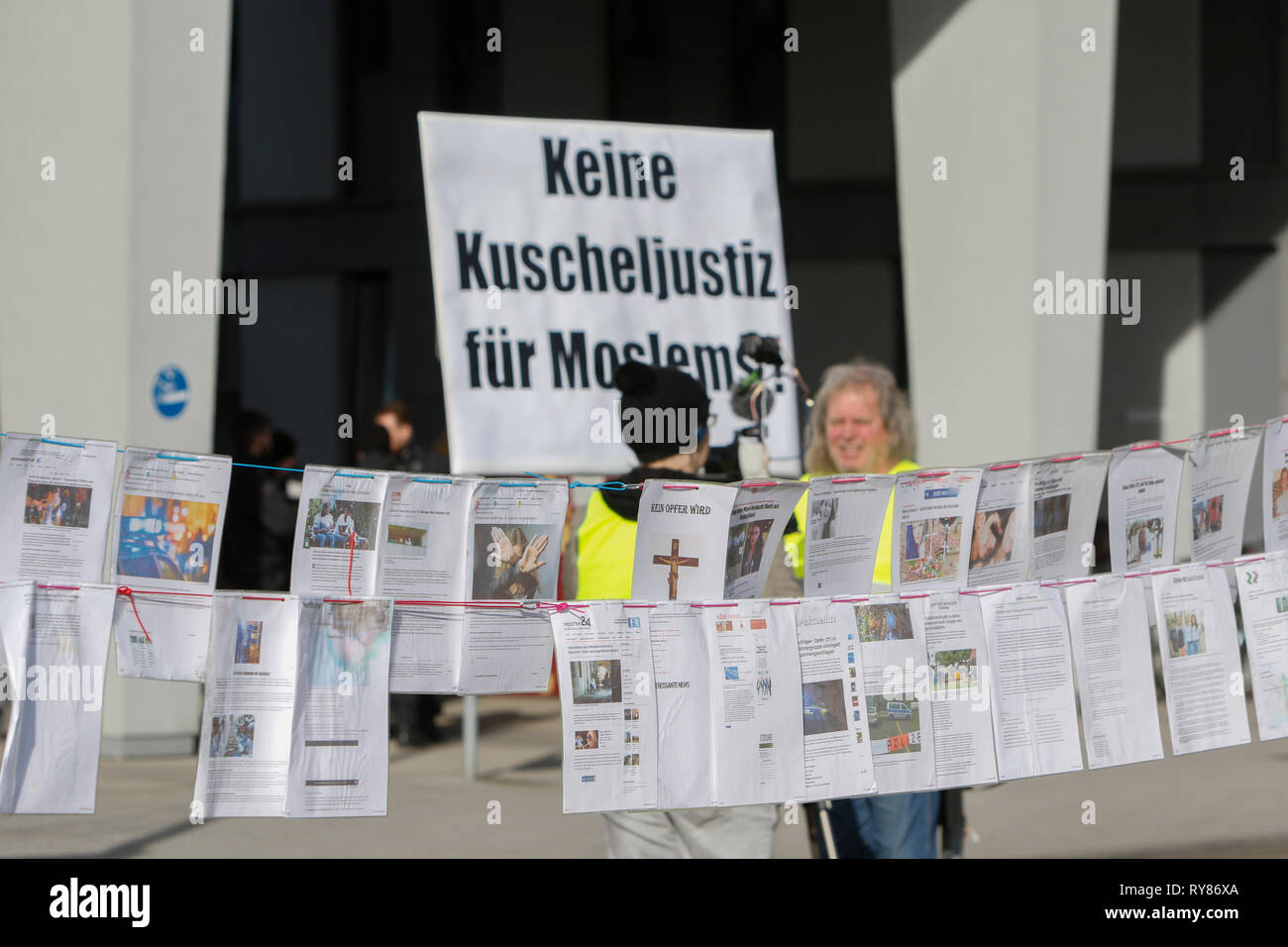 Wiesbaden, Deutschland. 12 Mär, 2019. Eine Demonstrantin hält ein Schild mit der Aufschrift "Keine weiche Gerechtigkeit für die Muslime", mit dem "Leine des Grauens' (Leine des Schreckens), eine Linie, die mit gedruckt Zeitungsberichte über angebliche Flüchtling Verbrechen, vor. Die Gerichtsverfahren gegen die irakische Asylbewerber Ali B. für den Mord an Susanna F. aus Mainz war letztes Jahr in Wiesbaden eröffnet. Mehrere rechtsradikale Organisationen ein Protest außerhalb des Court House gegen Flüchtlinge in Deutschland und für härtere Strafen für Flüchtlinge. Quelle: Michael Debets/Pacific Press/Alamy leben Nachrichten Stockfoto