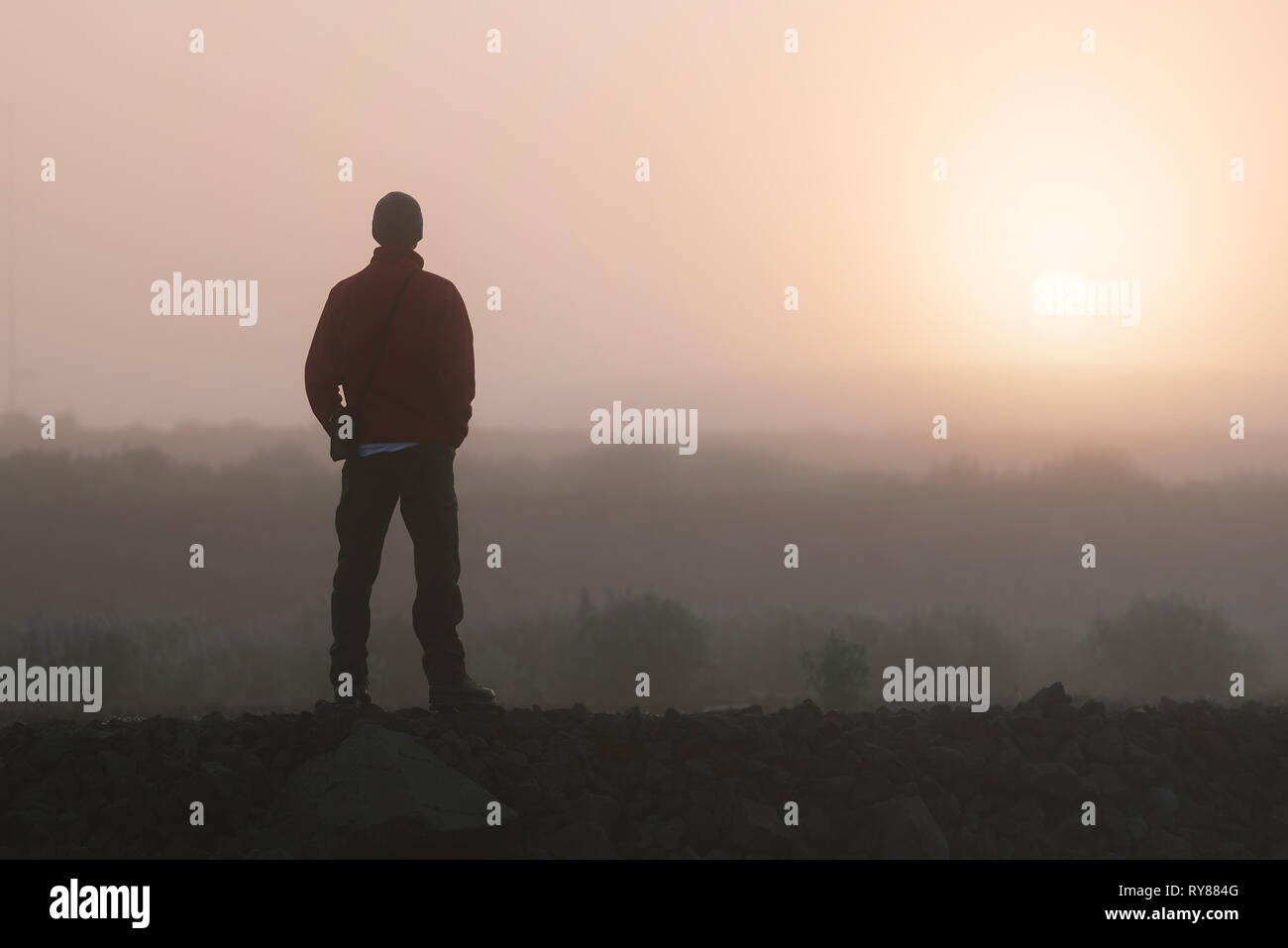 Der Mensch denkt an die aufgehende Sonne suchen. Morgen Landschaft mit Nebel Stockfoto