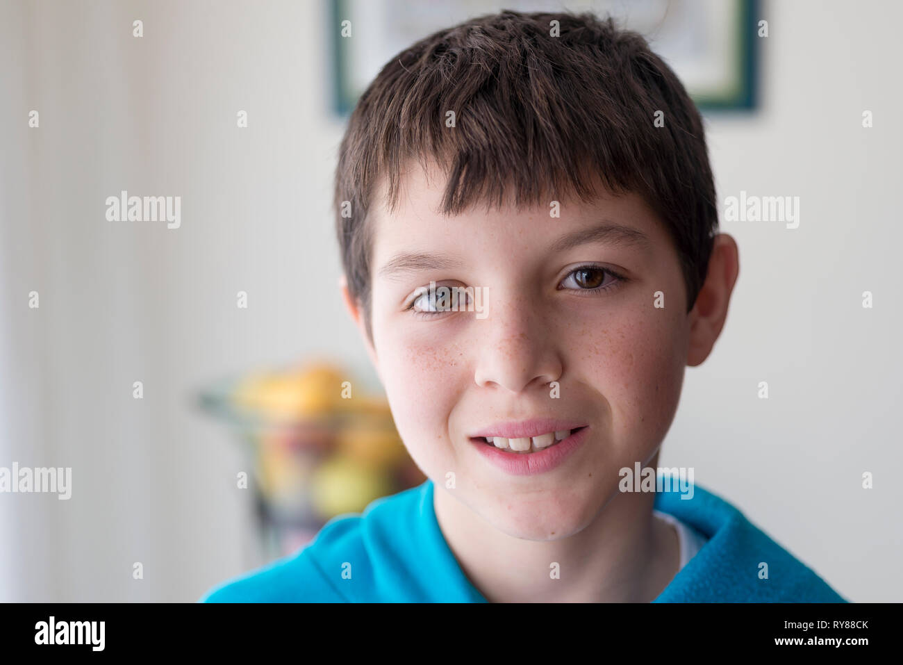 Close-up Portrait von lächelnde Junge gegen die Wand zu Hause Stockfoto