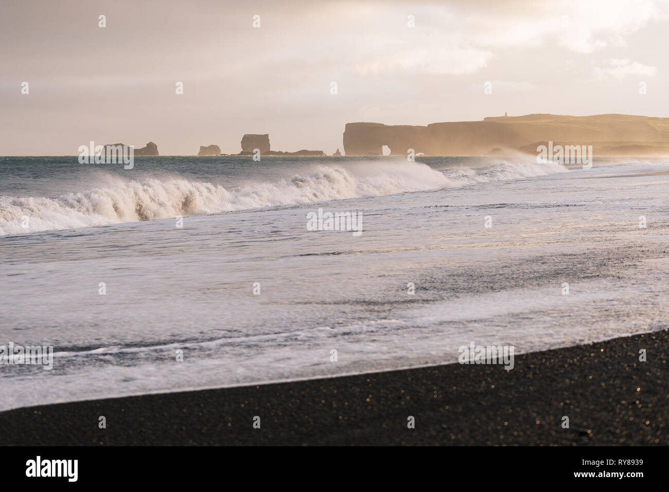 Reynisfjara Strand mit schwarzem Sand vulkanischen Ursprungs. Blick auf Kap Dyrholaey. Ein Sturm auf dem Meer mit großen Wellen. Touristische Attraktion von Island Stockfoto