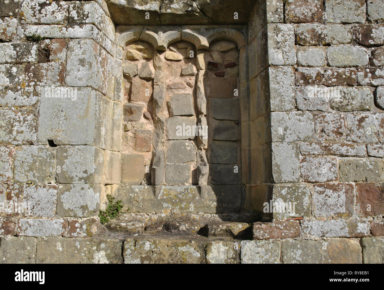 Ein alter Gemauerter, bogenförmige Fenster in eine Mauer aus Stein Stockfoto