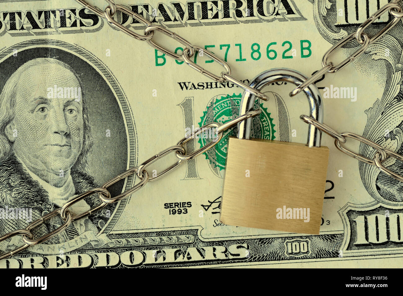 Nahaufnahme des Dollar Banknote mit Kette und einem Vorhängeschloss gesichert - Begriff der Versicherung, Kaution - in der finanziellen Sicherheit und Stockfoto