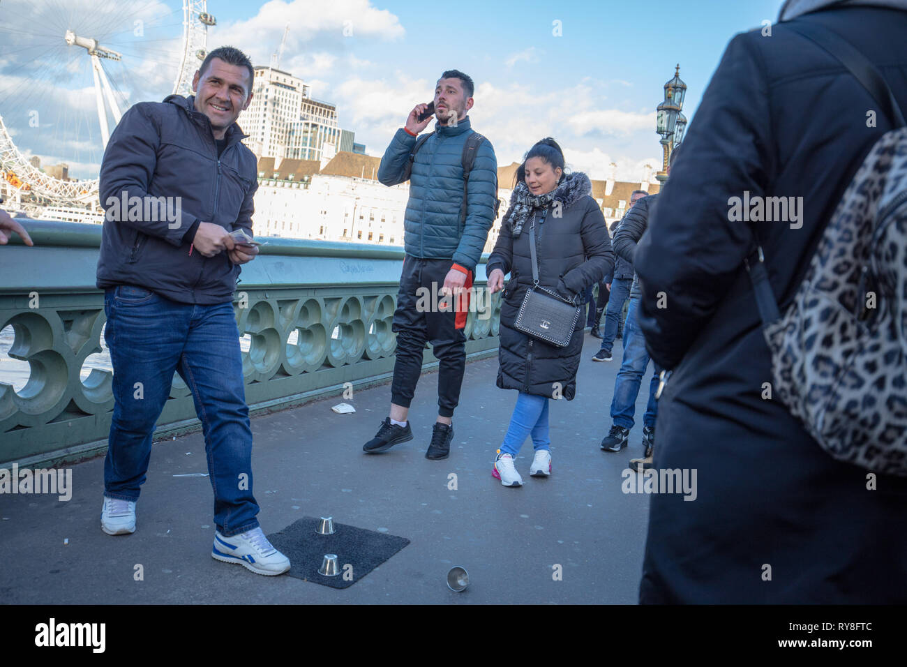 Gut organisierte Gruppen locken Touristen zu spielen und Ihren Urlaub Bargeld auf einer Kugel Spiel auf die Westminster Bridge, London, UK verbringen. Stockfoto