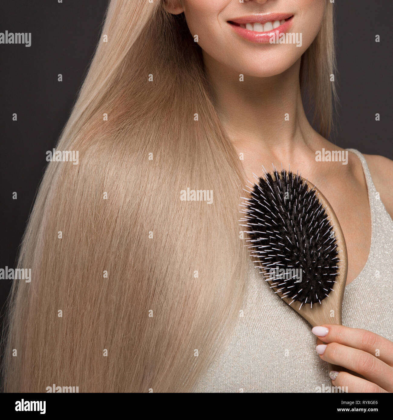 Schöne blonde Mädchen mit einem perfekt glatte Haare, klassische Make-up mit der Haarbürste in der Hand. Schönheit Gesicht. Stockfoto