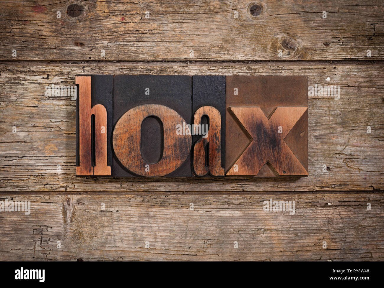Hoax, einzelnes Wort mit Vintage Buchdruck Blöcke auf rustikalen Holzmöbeln Hintergrund Stockfoto