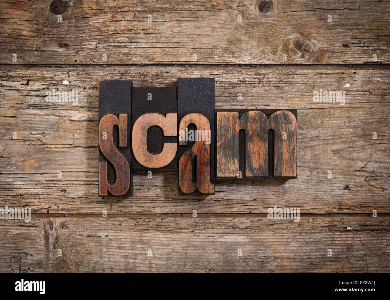Scam, einzelnes Wort mit Vintage Buchdruck Blöcke auf rustikalen Holzmöbeln Hintergrund Stockfoto