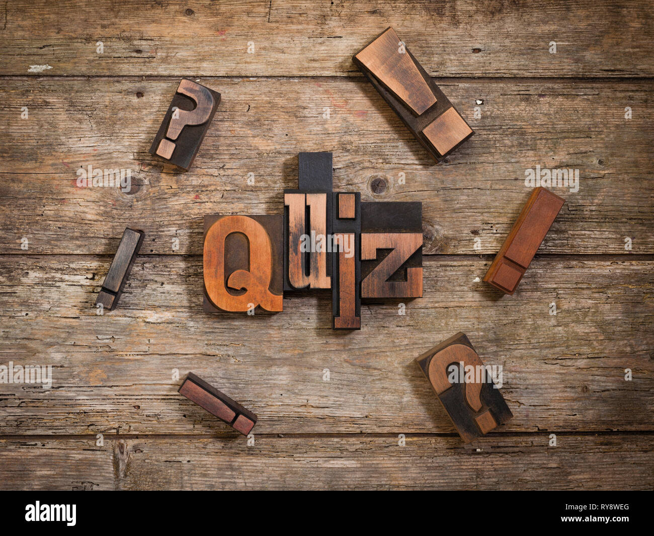 Quiz, einzelnes Wort mit Vintage Buchdruck Blöcke auf rustikalen Holzmöbeln Hintergrund von Ausrufezeichen und Fragezeichen umgeben Stockfoto