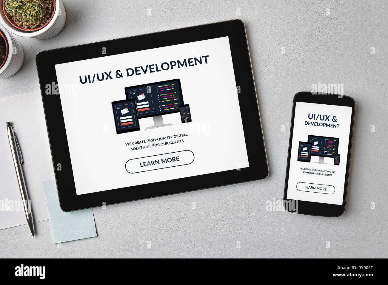 UI/UX-Entwurf und Entwicklung Konzept auf Tablet-PC und Bildschirm des Smartphones über graue Tabelle. Alle Inhalte werden von mir gestaltet. Flach Stockfoto