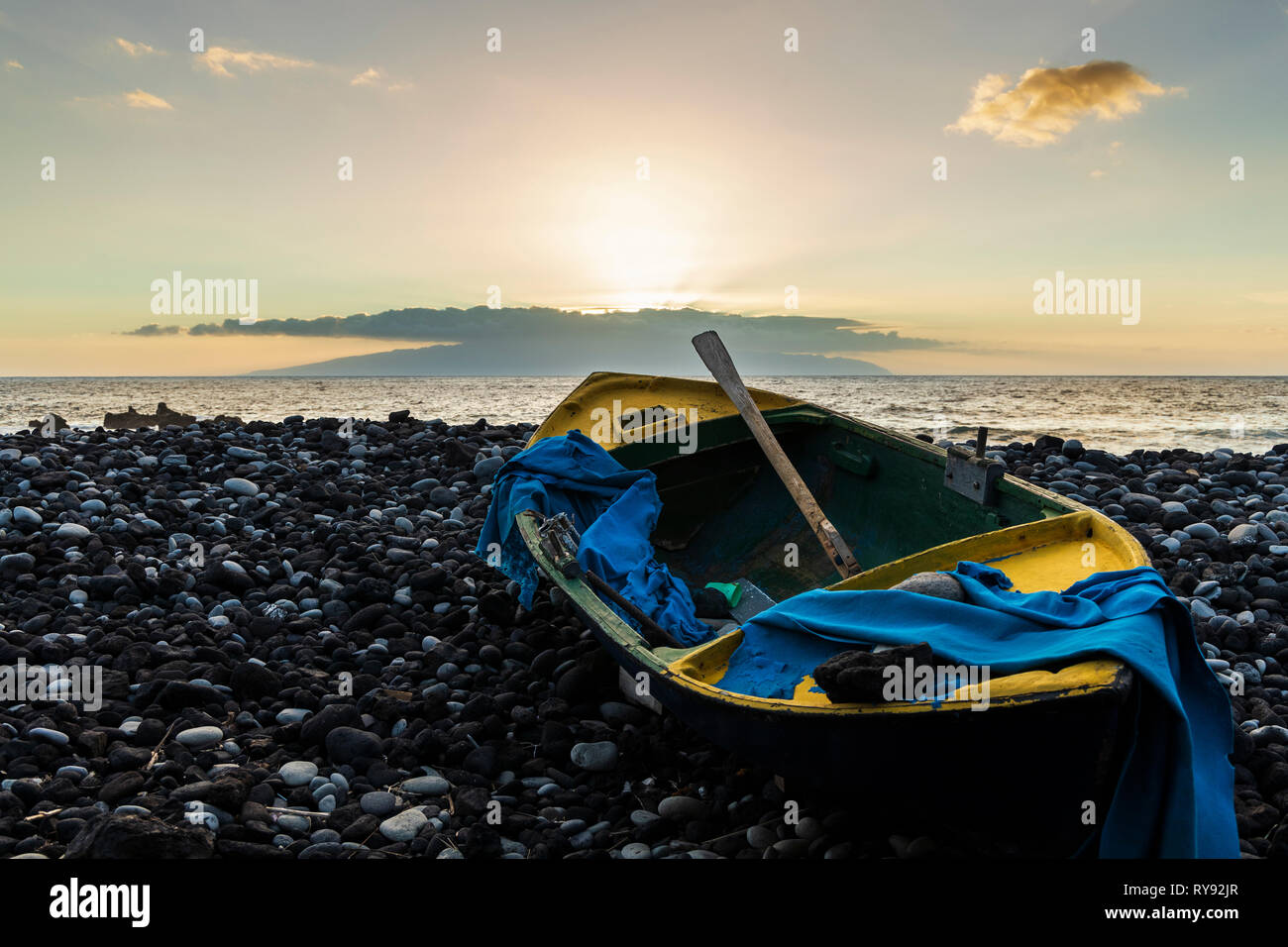 Holz- Boot auf steinigem Strand bei Sonnenuntergang mit Insel am Horizont, Fonsalia, Teneriffa, Kanarische Inseln, Spanien Stockfoto