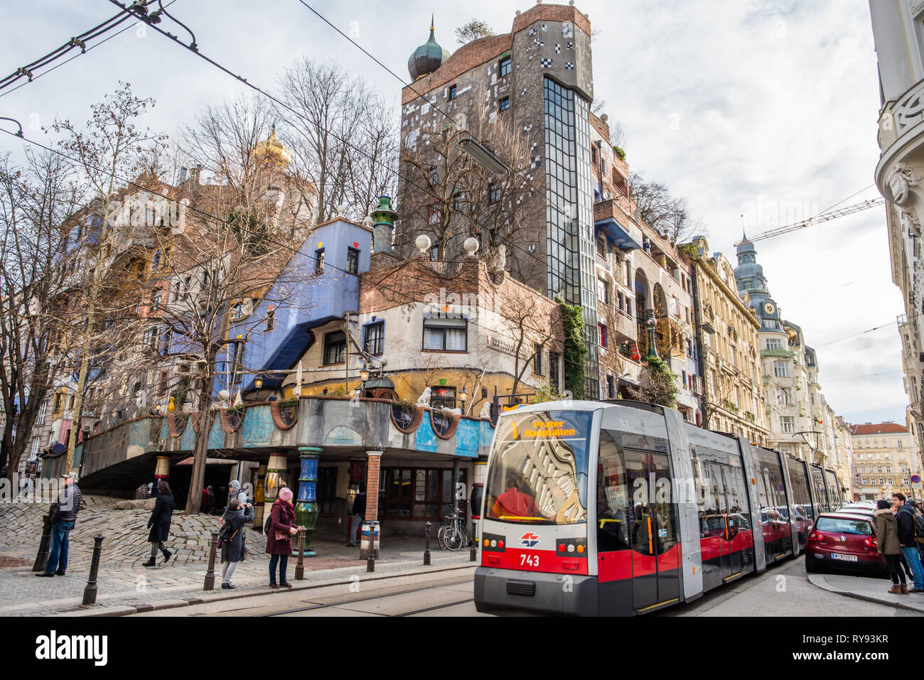 Eine Straßenbahn vorbei Hundertwasserhaus, expressionistischen Sehenswürdigkeiten und öffentlichen Wohnungsbau, vom Architekten Friedenreich Hundertwasser in Wien konzipiert. Österreich. Stockfoto