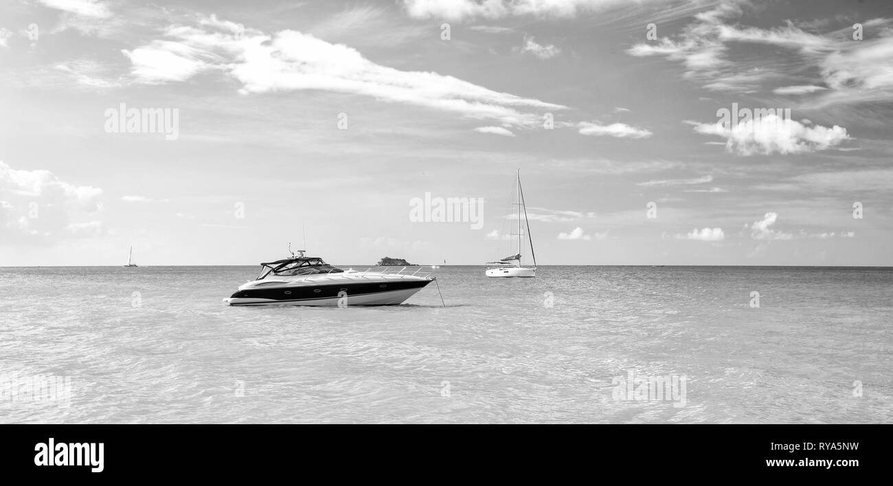 Schöne helle Blick auf exotische Bunte schöne marine Beach von Antigua St. Johns mit Boot auf blauem Wasser und Himmel mit kleinen Wolken im sonnigen weath Stockfoto