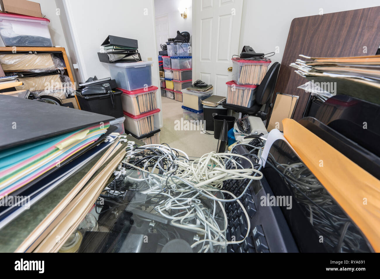 Unordentliches Büro Schreibtisch mit Akten, Schachteln, Unordnung, alte Anlagen und Lagerung. Stockfoto