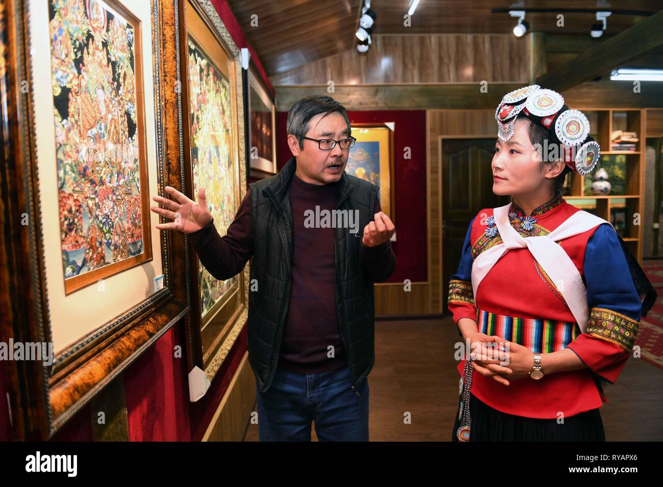 Peking, der chinesischen Provinz Yunnan. 13 Feb, 2019. Ventilator Yongzhen (R), ein Stellvertreter des 13. Nationalen Volkskongress (NVK), führt eine Forschung auf Thangka mit dianxiu Stickerei an Baisha Altstadt von yulong Naxi autonomen Grafschaft in Lijiang, im Südwesten der chinesischen Provinz Yunnan, 13.02.2019. Credit: Yang Zongyou/Xinhua/Alamy leben Nachrichten Stockfoto