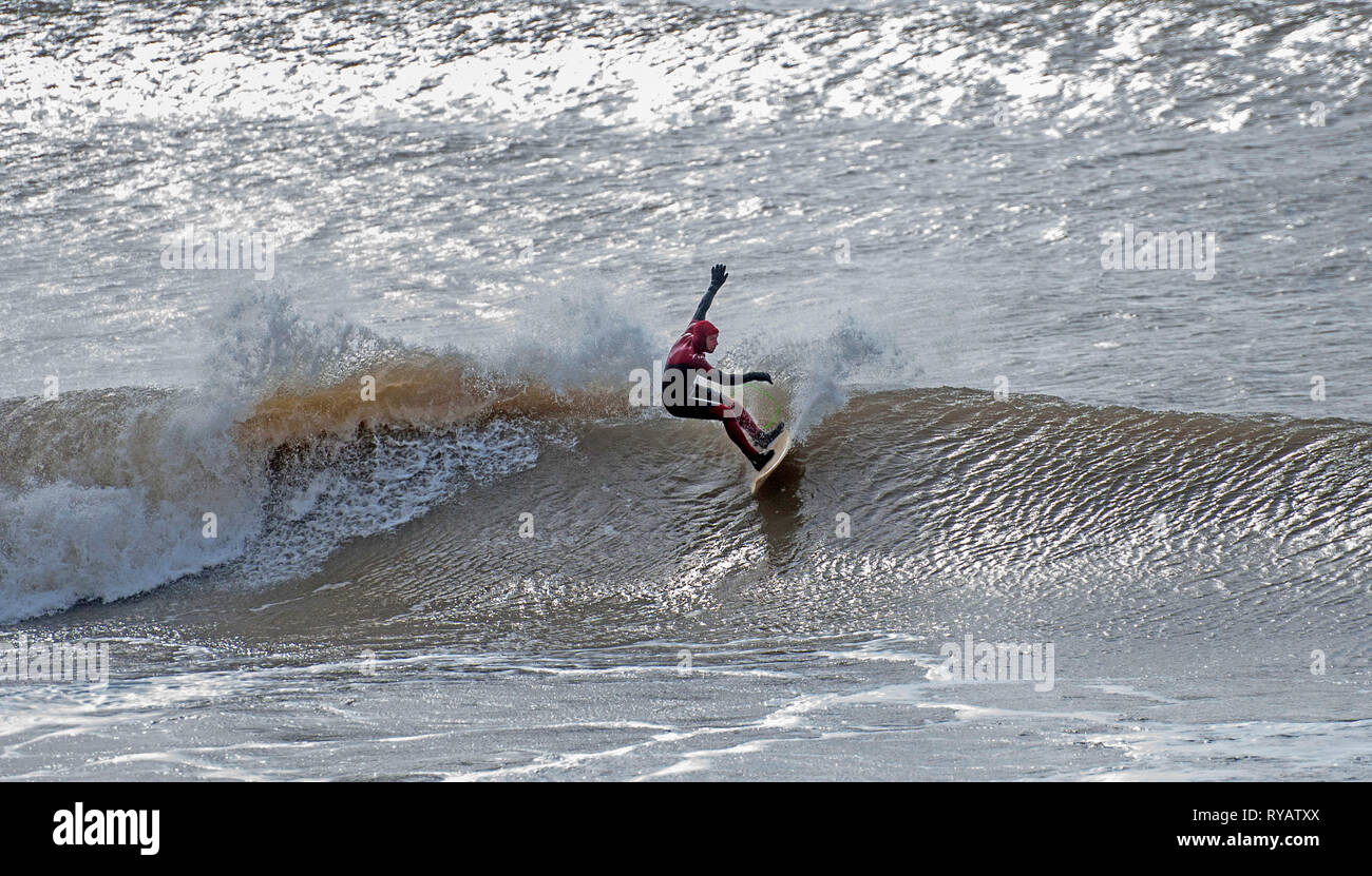 Swansea, Großbritannien. 13 Mär, 2019. Ein Surfer makign die Wellen an Langland Bay in der Nähe von Swansea heute Nachmittag mit dem Sturm Gareth swell erzeugt. Bild von Lisa Dawson Rees Credit: Phil Rees/Alamy leben Nachrichten Stockfoto