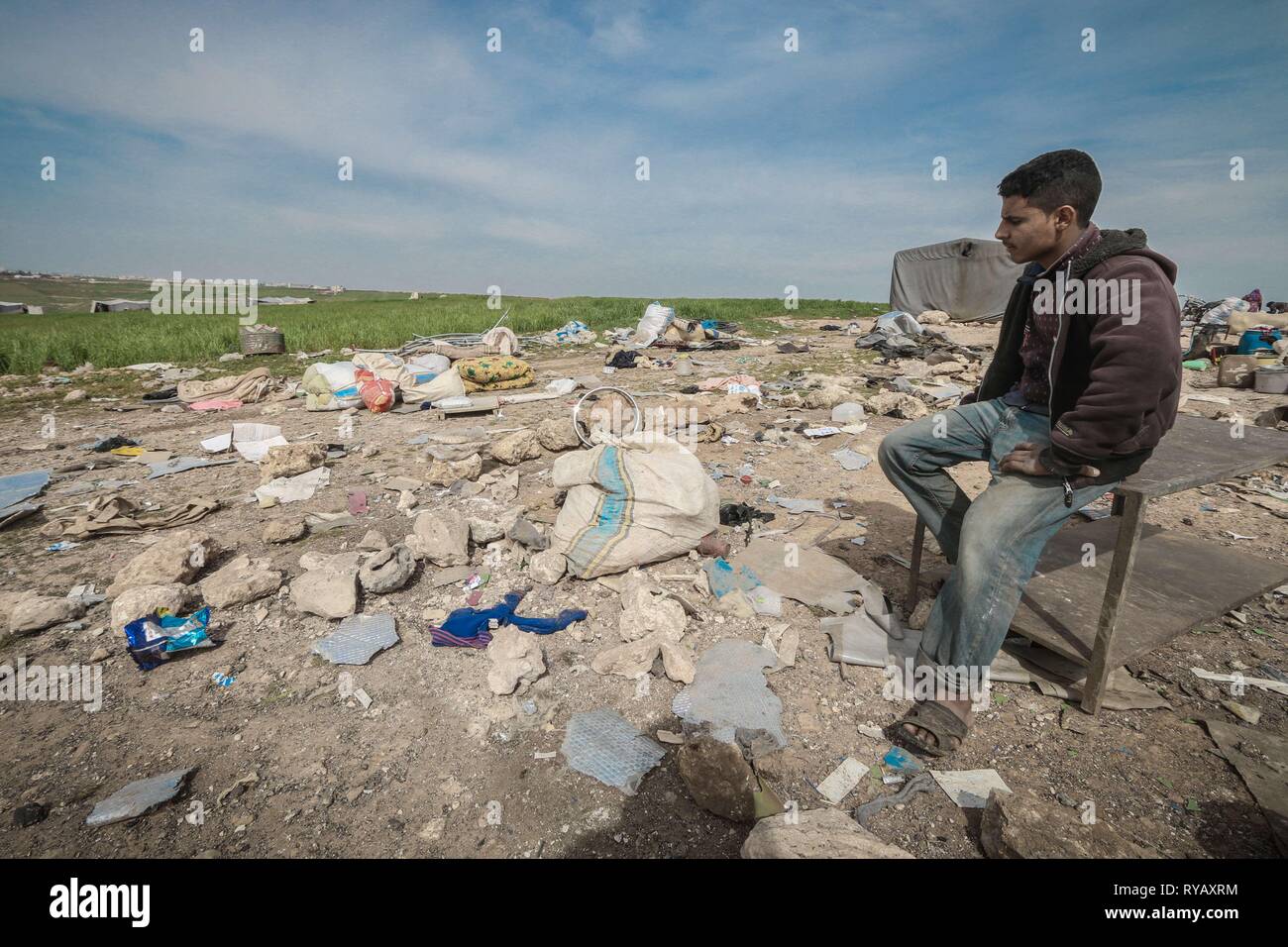 Saraqib, Idlib, Syrien. 13 Mär, 2019. Ein Mann sitzt an einem bauen, die durch die russischen Luftangriff zerstört wurde. Die Rebellen behaupten, dass die Russische Luftwaffe Angriff durchgeführt hat, zu den Rebellen kontrollierten Gebiet von Kafar Amim in Idib Provinz. Die russische Luftwaffe aktuell ist die Durchführung von Missionen gegen die Regierungstruppen in Syrien unter der Anforderung der syrischen Regierung. Credit: Mohamad Saeed/SOPA Images/ZUMA Draht/Alamy leben Nachrichten Stockfoto