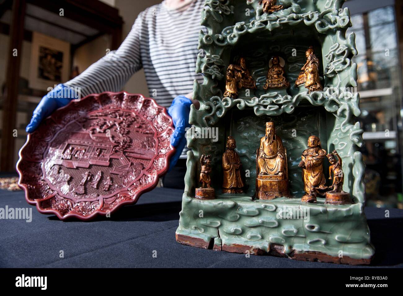 Die Objekte zum Angebot: - geschnitzt Rot Lack auf Holz core 1403-24 mit Szenen des kaiserlichen Haushalts 35 cm Durchmesser. - Ein paar gold Kissen endet vermutlich für ein Mitglied der königlichen Familie Ming - Longquan Heiligtum - Steinzeug celadon Glasur und Vergoldung Tongle Ära 1406. an der Oberseite des obersten daoistischen Gott des Donners Fahrten Fabeltier bezeichnet ein qilin Mitte Nische sind die drei Reine, Götter, der daoistischen Philosophie kapseln. Im Zentrum Celestial Worthys. In der Mitte in den Reverse Shot sichtbar wird, ist die CW von Promordial. In der unteren Grotte sind der Jade Kaiser cen Stockfoto