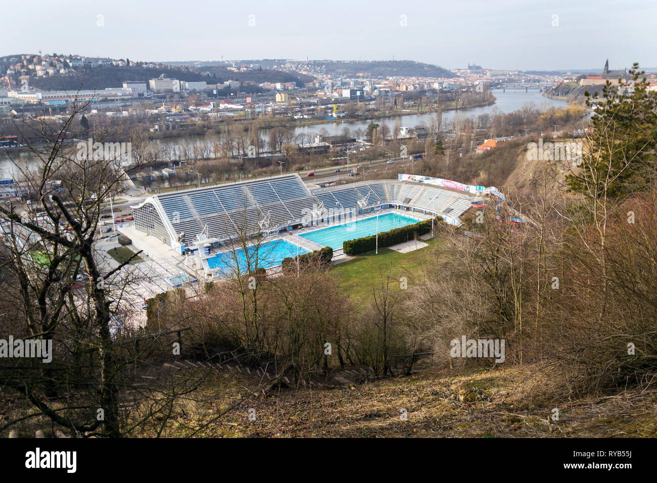 Größte Badelandschaft mit Innen- und Außenpools, Rodeln Wasserrutsche und tauchen Türme mit Moldau im Hintergrund, Podoli, Prag, Tschechische Stockfoto