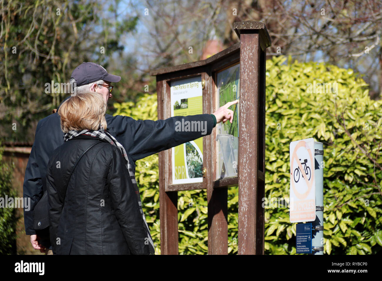 Touristen oder Einheimische schauen und zeigen auf Karte von der Universität Oxford Parks und Vorstand an einem sonnigen Tag im Winter/Frühjahr beachten Stockfoto