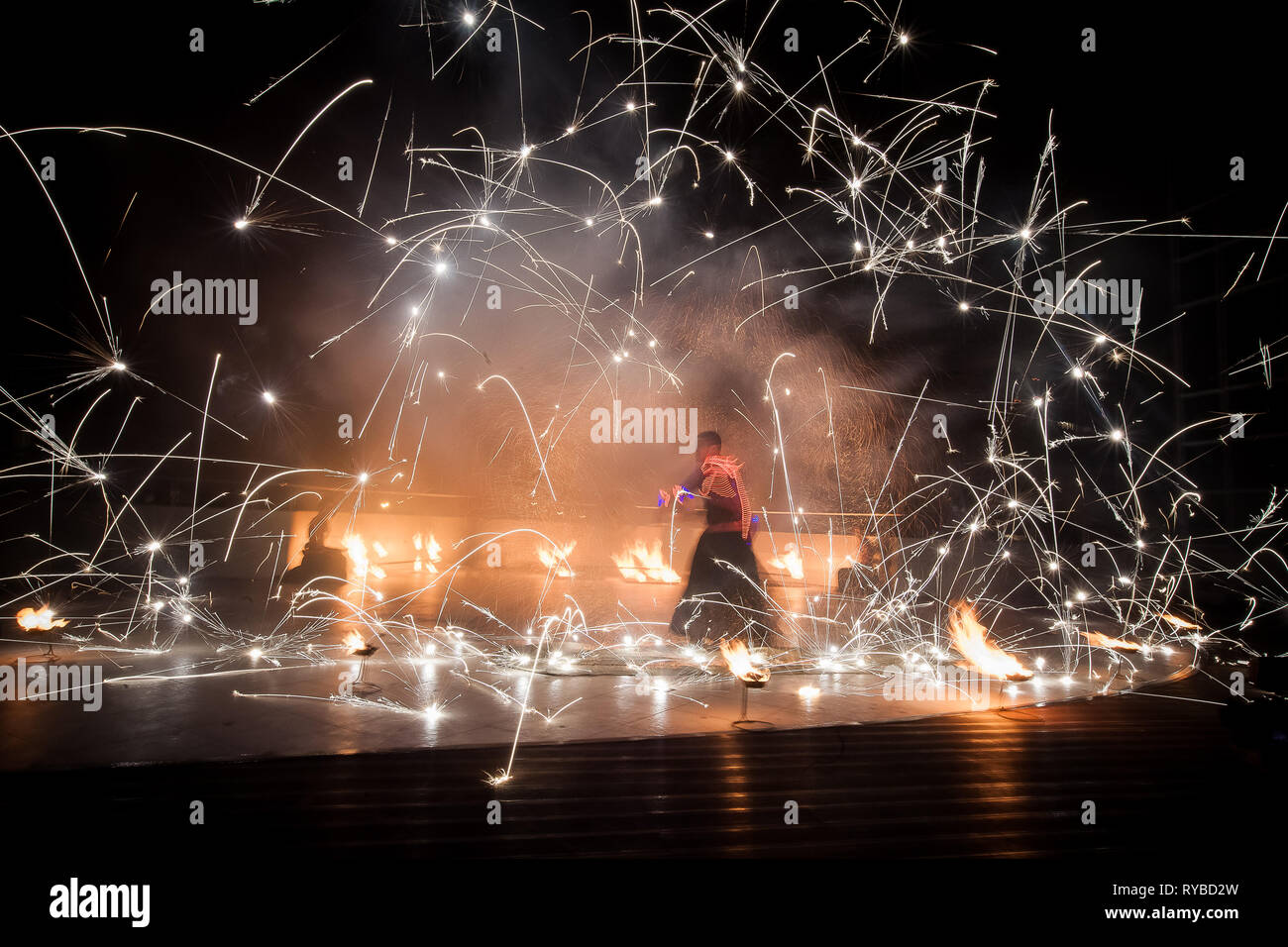 Erstaunlich, Feuershow, Tanz. Feuertänzer in wunderschönen Kostümen spielen mit bunten Flammen Stockfoto