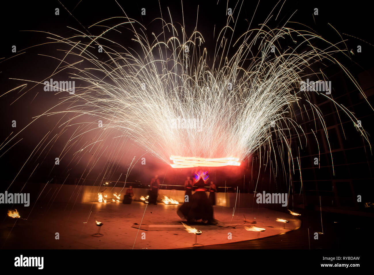 Erstaunlich, Feuershow, Tanz. Feuertänzer in wunderschönen Kostümen spielen mit bunten Flammen Stockfoto