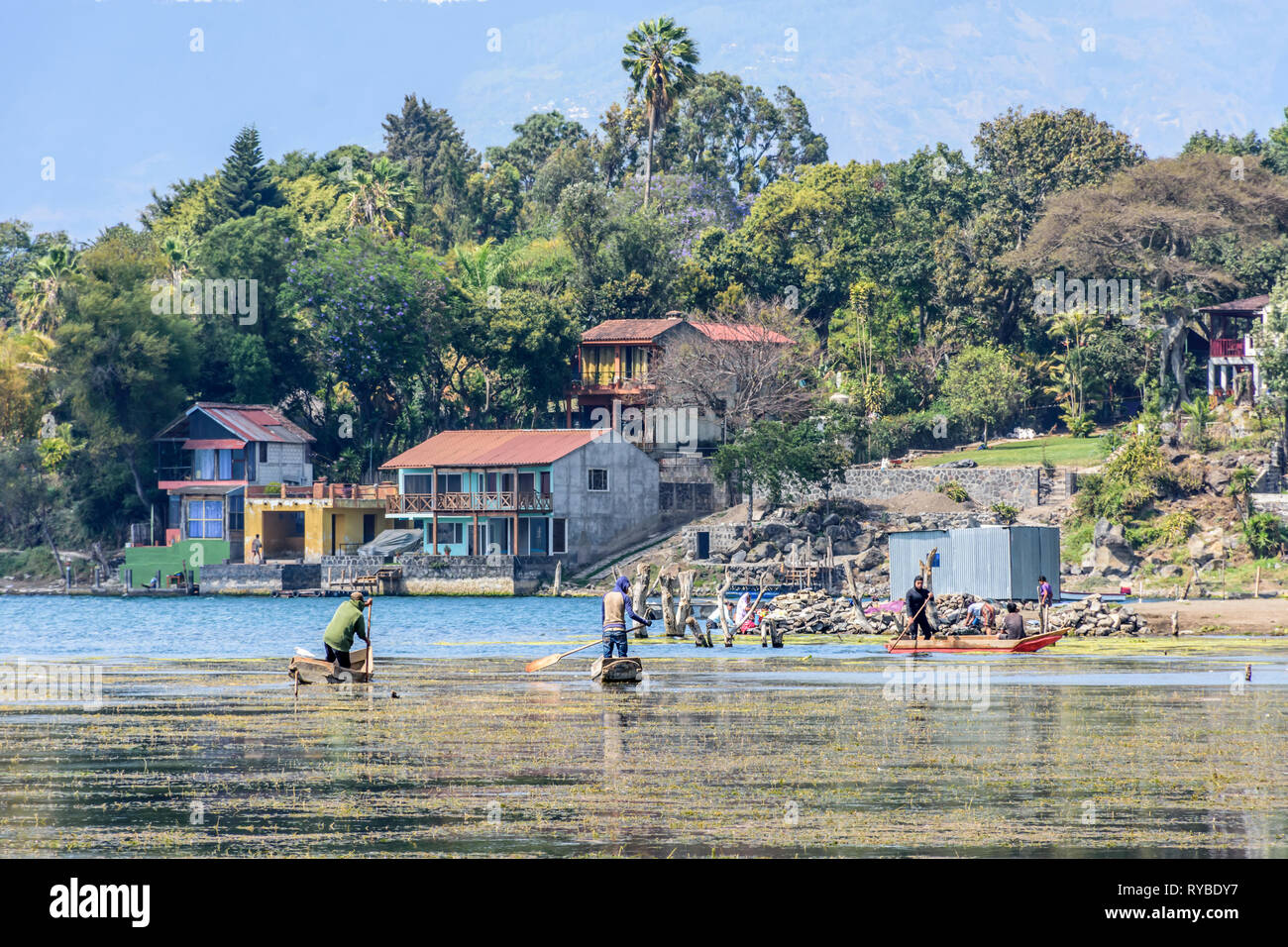 Santiago Atitlan See, Lake Atitlan, Guatemala - 8. März, 2019: Männer Paddel traditioneller Kanus in der Nähe von Lake Shore in der größten Stadt am See Stockfoto
