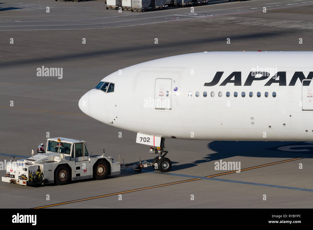 Eine Boeing 777-246 (er) mit Japan Airlines (JAL), die von einem Schlepper am Haneda International Airport, Tokio, Japan, gezogen wird. Stockfoto