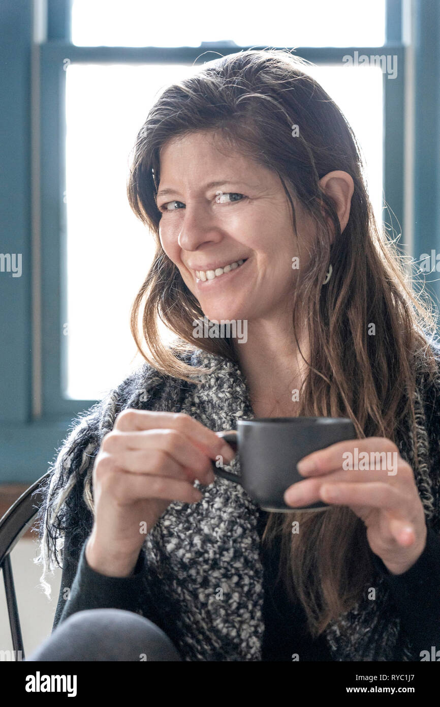 Frau mittleren Alters hält eine Tasse Tee Stockfoto