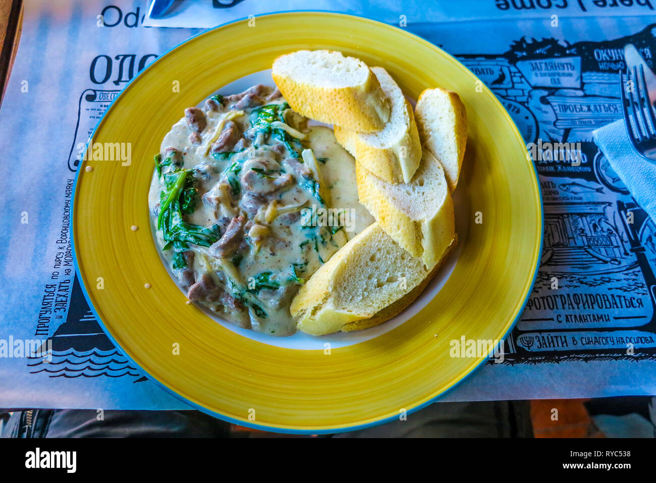 Ukrainische traditionelle Stroganoff mit geschnittenem Baguette auf der Grünen Platte Stockfoto