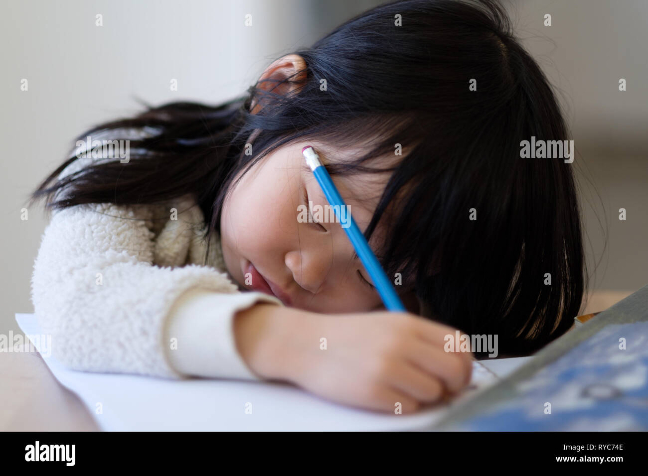 Asiatisches junges Kind Einschlafen während der Studie Stockfoto