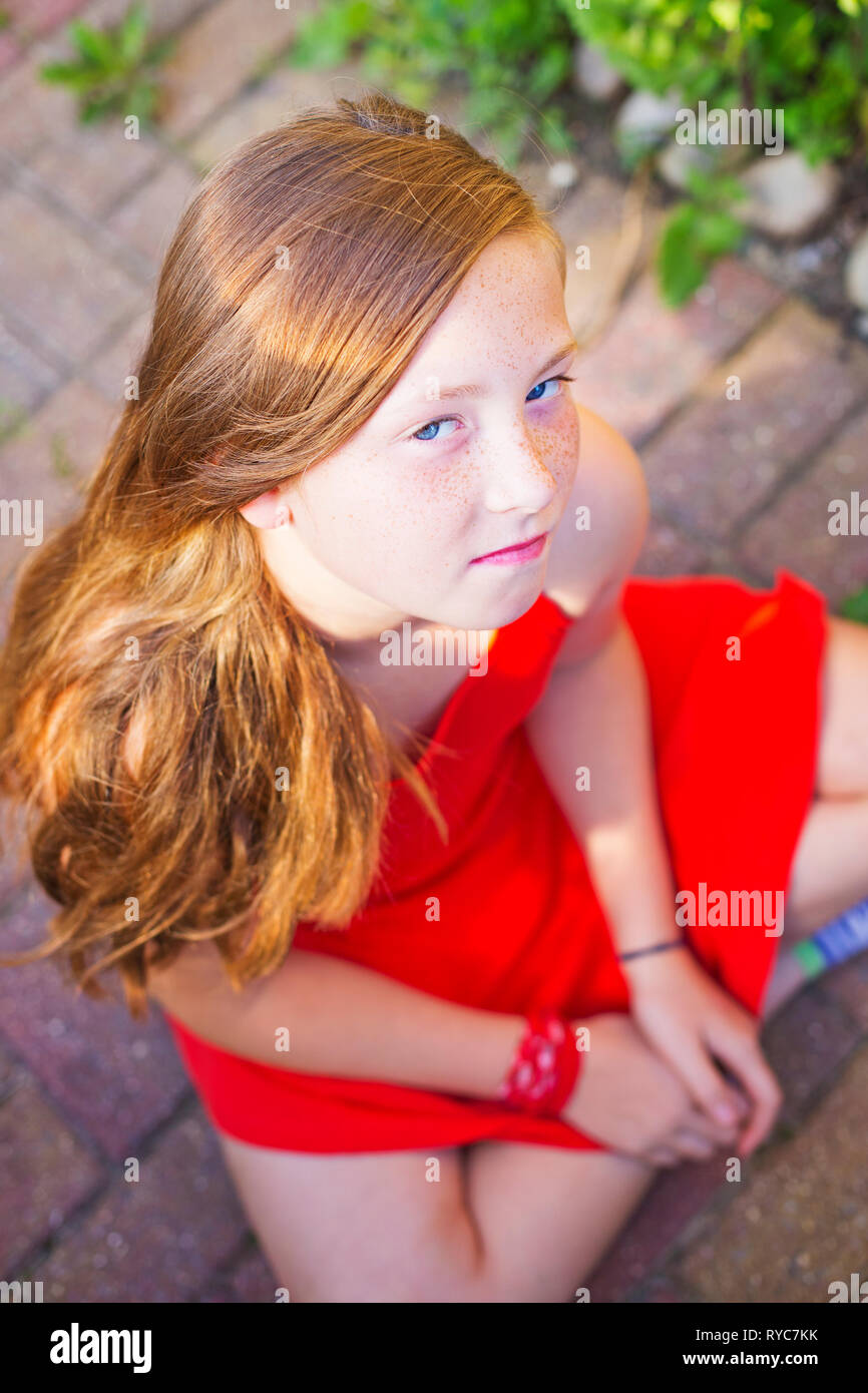 Ein junger Teenager Mädchen mit roten Haaren und roten Kleid Stockfoto