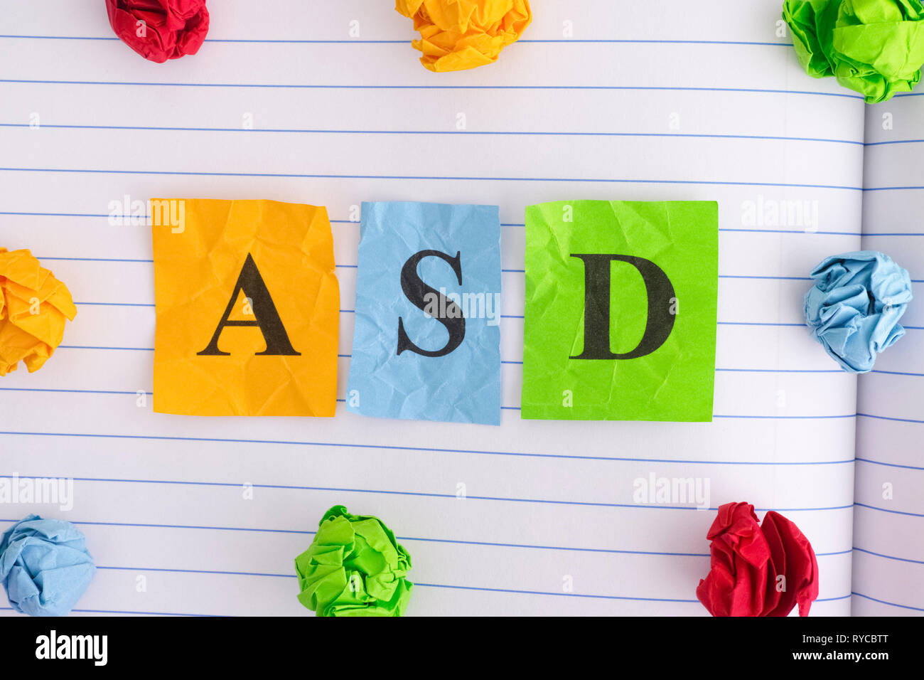 ASD. ASD (Autismus-Spektrum-Störungen) auf Notebook Blatt mit einigen bunten zerknittertes Papier Kugeln um ihn herum. Close Up. Stockfoto