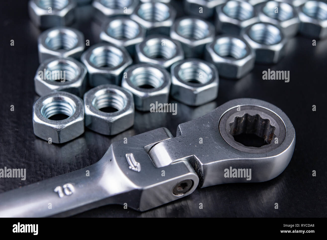 Neue verchromte key ring mit Riegel und Mutter. Zubehör für einen Mechaniker in einer Werkstatt. Der dunkle Hintergrund. Stockfoto