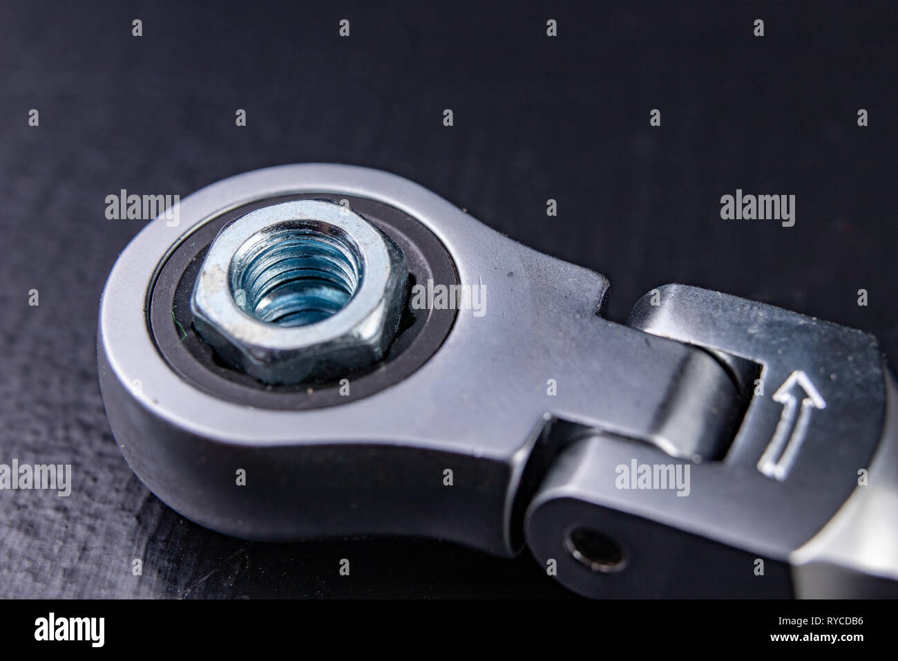Neue verchromte key ring mit Riegel und Mutter. Zubehör für einen Mechaniker in einer Werkstatt. Der dunkle Hintergrund. Stockfoto