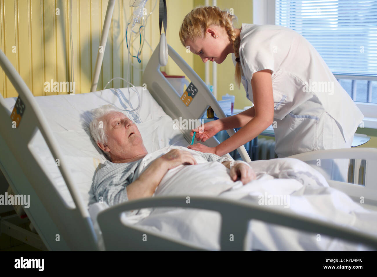 Eine Krankenschwester kümmert sich ein Patient in einem Krankenhausbett, Karlovy Vary, Tschechische Republik, Europa Stockfoto