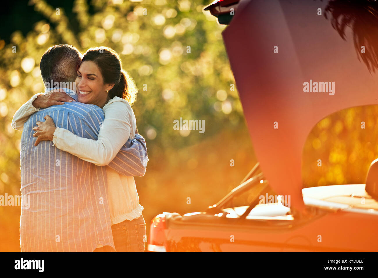 Reifes Paar umarmen neben ihrem Auto. Stockfoto