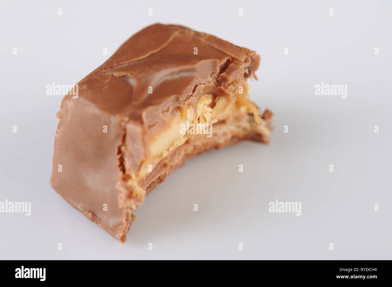 Stück Schokolade Schokoriegel beißen auf weißem Hintergrund Stockfoto