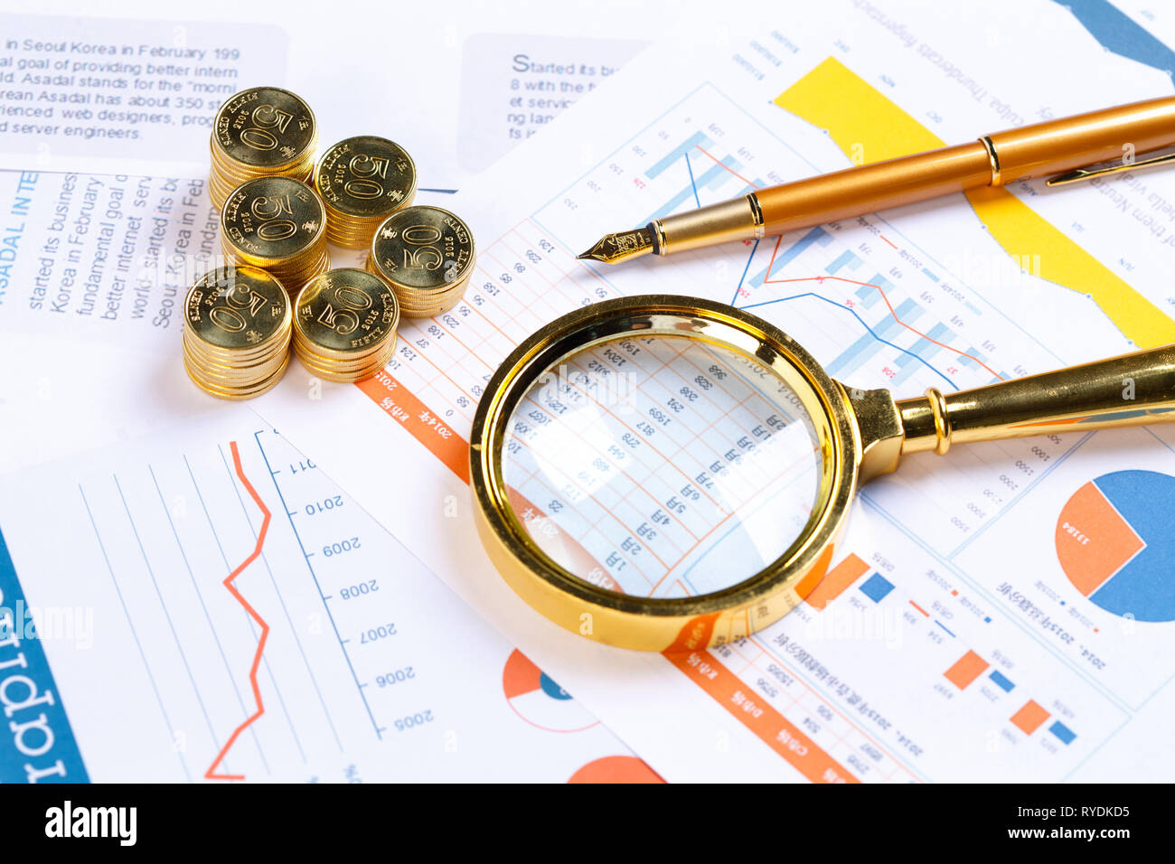 Eine Lupe und Münzen Stockfoto