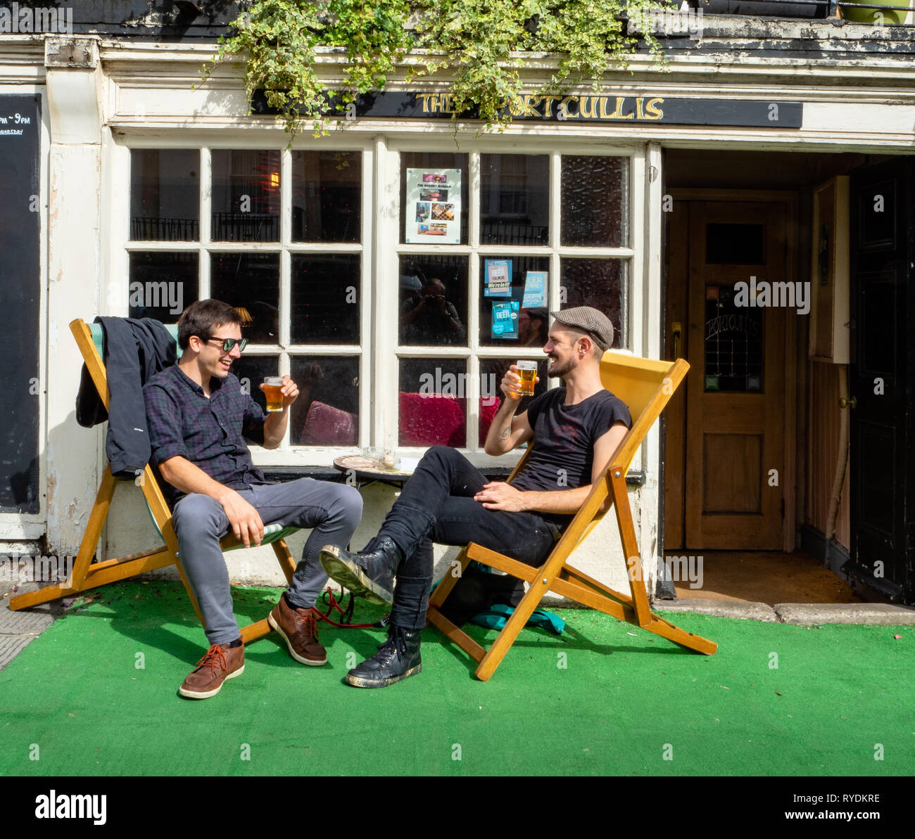 Freunde genießen Sie ein Bier in den Liegestühlen außerhalb des Portcullis eine lokale Real Ale Pub im Dorf Clifton Bristol UK Stockfoto