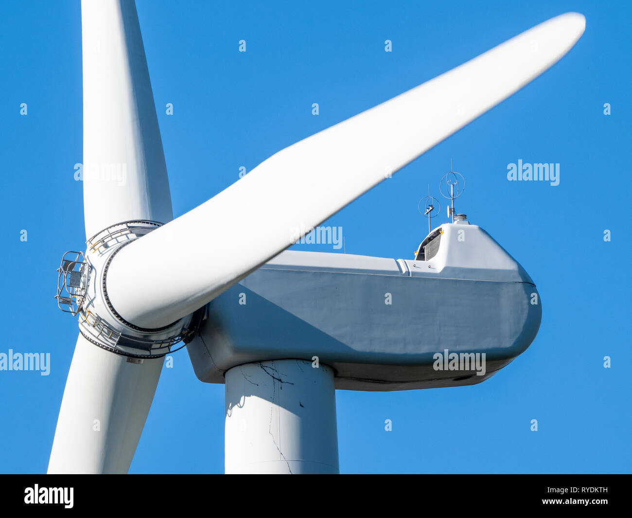 Detail einer großen horizontalen Achse Wind Turbine in Bewegung mit Turm und Gondel, Rotorblätter, die Häuser der Stromerzeuger - South Wales, Großbritannien Stockfoto